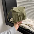 Sac bandoulière en daim vert olive avec franges et rabat tenu à la main - Vert