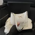 Bolso de hombro blanco con lazo dorado dentro de una caja de regalo negra de lujo - Blanco