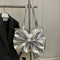 Silver metallic tote bag featuring a large bow design with stylish slender shoulder straps - Silver