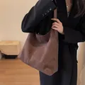 Μεγάλη σκούρα καφέ hobo τσάντα από συνθετικό σουέτ φορεμένη από μοντέλο σε μίνιμαλ στυλ - Καφέ