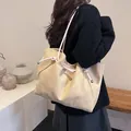 Minimalist beige suede tote bag with thick cotton rope handles shown on a model - White