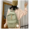 Detail of light green minimalist backpack with plush charm on female student's back - Green