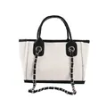Detail of white canvas bucket bag featuring black leather handles and silver chain detail - Small White