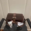 Bolso bandolera de cuero café oscuro con hebilla plateada vintage y correa larga - café