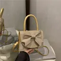 Elegant gold rhinestone handbag with oversized bow detail and pearl handle strap - Gold