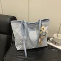 Light blue floral quilted tote bag with dual handles and teddy bear charm on wood desk - With Pendant / Blue