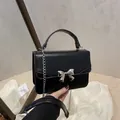 Chique zwarte mini crossbody tas met zilveren ketting en metalen strik detail - Zwart