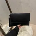Minimalist black faux leather envelope clutch bag with detachable wrist strap and matte finish - Black