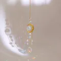 Dettaglio dell'acchiappasole luna dorata con cristalli che riflettono macchie arcobaleno - Stile Faccia di Luna Perla di Cristallo Rosa