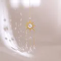 Detail van gouden zonnevanger met kristallen druppel en sprankelende lichtreflectie - Zonnestraal Stijl (Stijl Een)