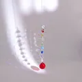 Macro detail of suncatcher with spiral metal wire and multifaceted red crystal ball - Multicolor Beads With Red Ball (Swivel Ring Style)