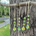 Dettaglio macro di 6 acchiappasole in cristallo con rivestimento AB su un ramo d'albero - Stile Foglia d'Acero Cangiante