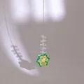 Crystal flower suncatcher with green and yellow petals creating rainbows on a grey background - Iridescent Green Crystal Flower