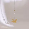 Details einer goldenen Wanddeko mit fliegendem Metallvogel, Sonnenstern und Kristall - Vogel Und Stern Stil