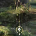 Close-up of golden suncatcher with faceted crystal ball hanging from a natural tree branch - AB Colorful Crystal Ball (Small)
