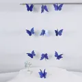 Detalle de guirnaldas de mariposas 3D azules brillantes colgadas en pared blanca - Aprox. 2m de largo / Azul marino