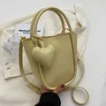 Borsa a secchiello giallo crema con ciondolo a cuore e tracolla regolabile da donna - Giallo