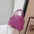 Borsa a conchiglia in pelle viola motivo litchi con tracolla a catena e parti metalliche - rosa acceso