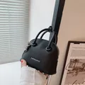 Mini borsa a conchiglia in pelle martellata nera con catena argentata e manici - Nero