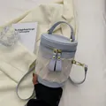 Bolso tipo cubo de moda en azul claro y blanco crema con textura de ondas y herrajes dorados - Azul