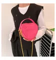 Dettaglio della borsa rosa a forma di cuore con catena dorata e logo in rilievo - Rosa