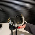 Mini borsa a secchiello in vernice nera con manico di perle e catena a cuore - Nero