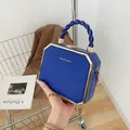 Dark blue hexagonal hard shell bag with gold metal trim and woven handle - Blue