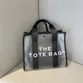 Modern semi-transparent frosted tote bag with black trim and bold THE TOTE BAG text print - Black