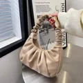 Elegante borsa hobo beige a pieghe con manico arricciato mostrata in uno scatto a mano - Cachi