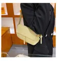 Dettaglio della borsa a spalla in pelle giallo pallido con patta e tracolla su modella - Giallo