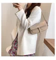 Elegante borsa baguette beige in ecopelle indossata su una giacca bianca - Cachi