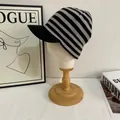 Detailed close-up of knitted black and gray striped beanie with brim on a model head - M / Black