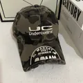 Close-up of distressed camouflage baseball cap with UC Undercontrol embroidery and vintage torn edges - M (56-58cm) / Camouflage