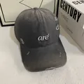 Nahaufnahme einer verwaschenen grauen Cap mit weißer Stickerei und Rissen im Stoff - M (56-58cm) / Grau