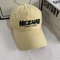 Detail view of embroidered lettering and distressed fabric on a yellow baseball cap - M (56-58cm) / Yellow