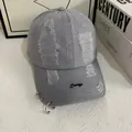 Close-up of gray cotton baseball cap with distressed holes and metal rings decoration - M (56-58cm) / Light Gray