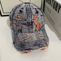 Dettaglio cappello baseball in denim vintage con fodera arancione a contrasto e strappi - M / Denim Blu Con Cuciture Arancioni