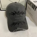 Detailed view of black flame embroidery and distressed edges on a vintage baseball cap - M (56-58cm) / Gray