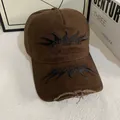 Close-up of flame embroidery and distressed frayed edges on brown cotton baseball cap - M (56-58cm) / Coffee