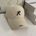 Detailopname van beige katoenen baseballcap met R-borduurwerk en sierstiksels - M(56-58cm) / Broken Wit