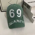 Detailed close-up of dark green baseball cap featuring white 69 embroidery and washed canvas - M (56-58cm) / Green