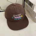 Détails des motifs floraux brodés et typographie sur une casquette snapback marron - M (56-58cm) / café