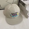Close-up of beige flat brim baseball cap featuring colorful graphic embroidery and floral patterns - M (56-58cm) / Off White