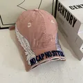 Close-up of pink baseball cap featuring white wing embroidery and distressed brim details - M / Pink