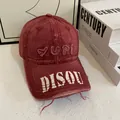 Detailed view of vintage washed red cotton baseball cap with distressed embroidery details - M (56-58cm) / Burgundy