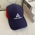 Gorra de 5 paneles azul marino y roja con bordado blanco sobre una mesa minimalista blanca - Mediano / Azul Marino+Rojo