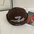 Detail of dark brown docker hat featuring MASIC embroidery and colorful woven wavy patterns - M (56-58cm) / Coffee