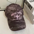 Dettaglio del ricamo rosa con testo 'CHASE AFTER' su cappello da baseball camouflage - M / caffè