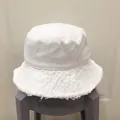 Détail d'un chapeau bob en toile blanche avec bords effilochés et finitions frangées - M (56-58cm) / Blanc