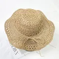 Detail of hand-woven straw sun hat showing intricate texture and decorative bow tie - M (56-58cm) / Khaki